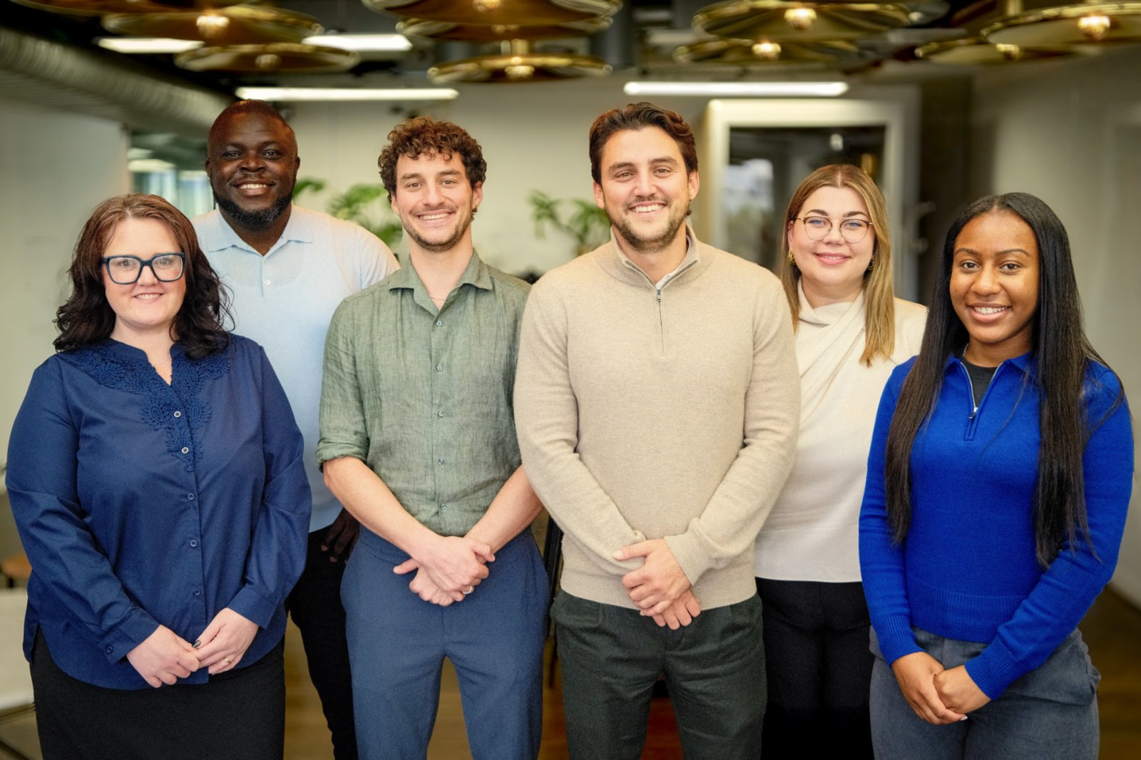 Six members of the Hedgerow Homecare office team standing together and smiling